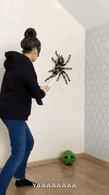a woman is playing with a spider on the wall .