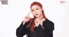 a woman with red hair is smiling and wearing a name tag that says ' statv ' on it