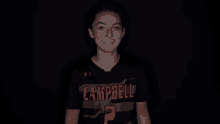 a woman wearing a black shirt with campbell written on it