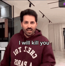a man wearing a maroon hoodie with the words i will kill you on it
