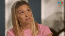 a woman in a pink shirt is looking up at the sky