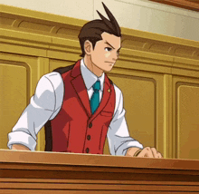 a man in a red vest and tie is standing in front of a podium .