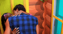 a woman in a plaid shirt is hugging a man in a blue plaid shirt