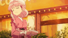 a girl with pink hair is holding a notebook in front of a building that says coffee
