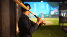 a man holding a baseball bat with a head logo on the handle