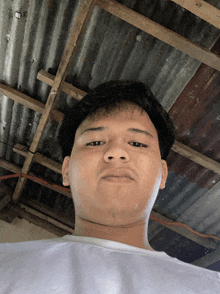 a man in a white shirt looks down at the camera