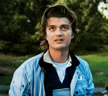 a man wearing a blue jacket with the letter g on the front