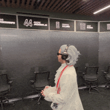 a man wearing headphones is standing in front of a wall with the number 44 on it