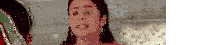 a woman is sitting on a couch talking to another woman and making a face .