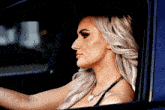 a woman with blonde hair is sitting in a car