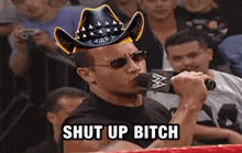 a man wearing a cowboy hat is singing into a microphone with the words shut up bitch written below him