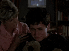 a woman is hugging a man in a room
