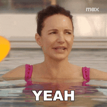 a woman in a pink bikini is in a pool saying yeah
