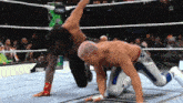 two men are wrestling in a ring and one of them is wearing a blue and white outfit