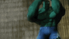the hulk is standing in front of a brick wall in a room .