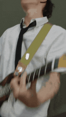a man in a tie is playing a guitar