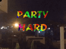 a colorful sign that says party hard on a dark background