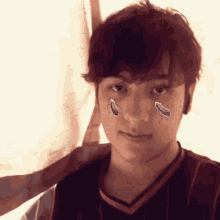 a young man with tears on his face is wearing a jersey