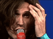 a close up of a person 's face with a microphone in front of it
