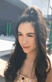 a close up of a woman 's face with her hair in a half ponytail