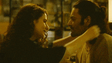 a man and woman are hugging each other in a living room .