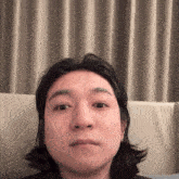a close up of a man 's face with long hair