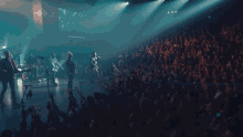 a man singing into a microphone in front of a crowd with their hands in the air