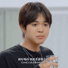 a young man is holding a glass of water and asking if he can drink all