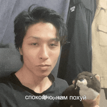 a man holding a stuffed animal with a foreign language caption