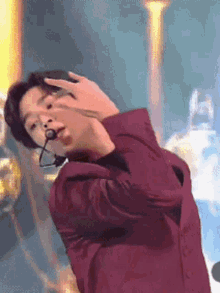 a man in a red suit is dancing with a microphone in his mouth