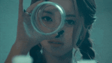 a woman looking through a magnifying glass with a black spot on her nose