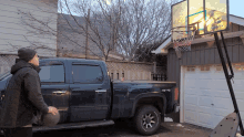 a man playing basketball next to a black truck that says 4x4