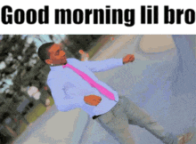 a man in a blue shirt and pink tie is dancing in front of a sign that says " good morning lil bro "