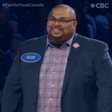 a man in a suit and plaid shirt has a name tag that says alan