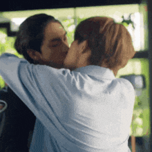 a man and a woman are kissing and hugging each other .