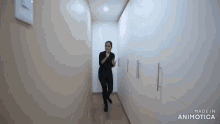 a woman is walking down a hallway with the words made in animotica on the bottom