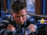 a man in a blue and white plaid shirt is sitting in a restaurant