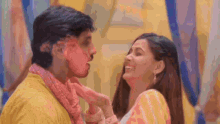 a man and a woman are kissing and the woman is holding the man 's face .