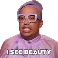 a man wearing glasses and a purple shirt has the words i see beauty above his head