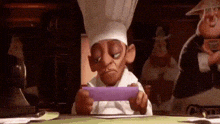 a cartoon chef is sitting at a table with a piece of paper in his hand .