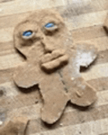 a gingerbread man with a face made out of sand on a wooden table .