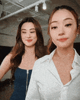 two women are standing next to each other and smiling for the camera