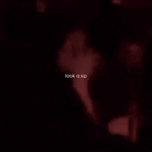 a blurry picture of a man and woman kissing with the words took a sip below them