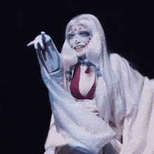 a woman in a white costume with red dots on her face
