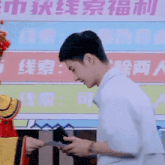 a man in a costume is standing next to another man with chinese writing on the wall behind them