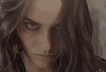 a close up of a woman 's face with a serious look on her face and long hair .