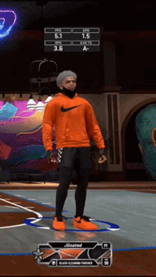 a man wearing an orange nike hoodie is standing on a basketball court