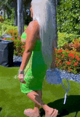 a woman in a green dress with the word @adore on the bottom right