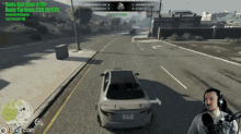 a man is playing a video game with a car driving down the road