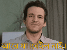 a man is smiling in front of a sign that says ' aaro ' on it